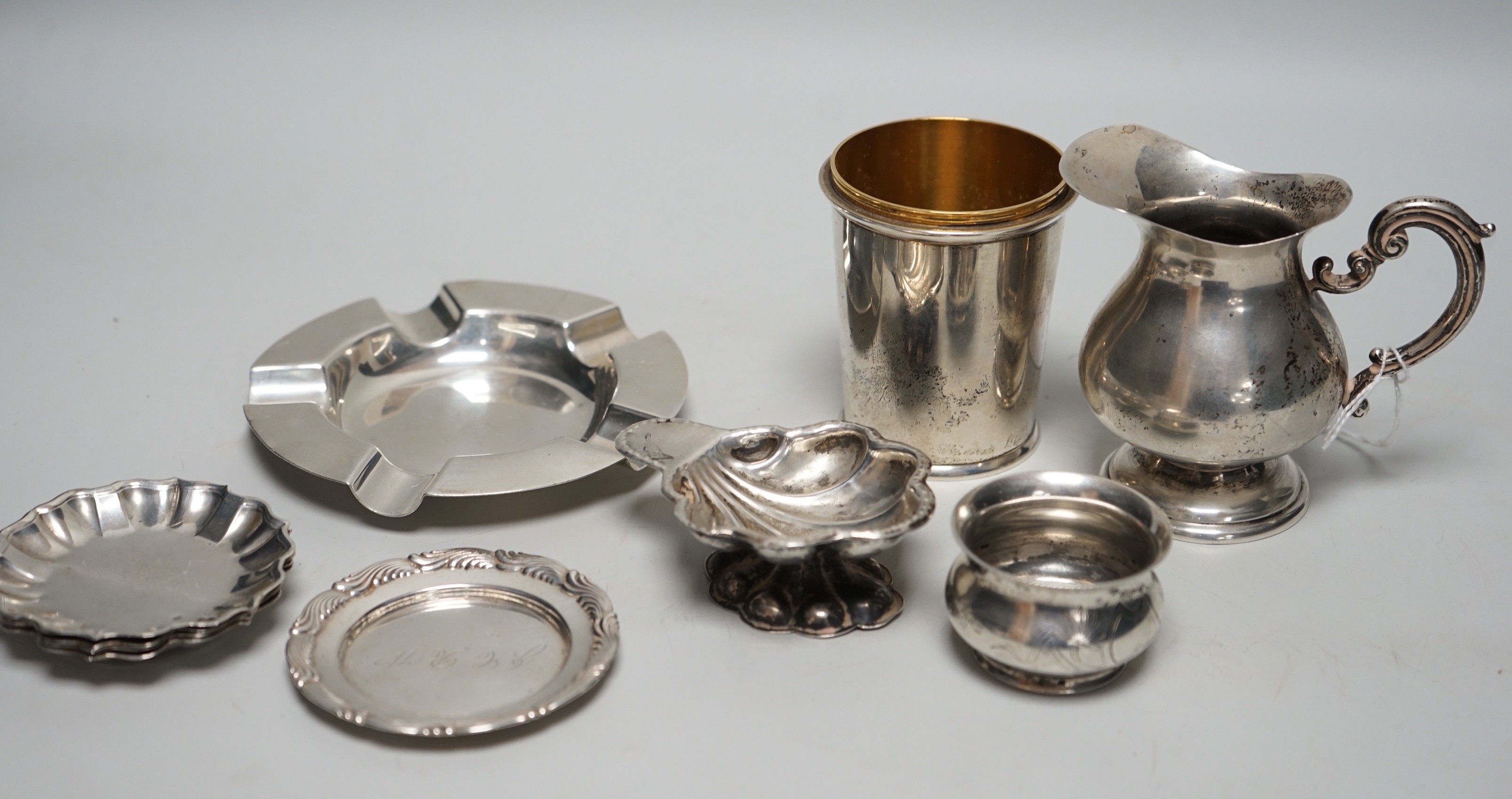 Sundry small silver, including a set of four 800 standard white metal small dishes, a similar shell salt and cream jug, a Tiffany & Co sterling small dish, a modern silver cup base (top missing), a silver ashtray and a R